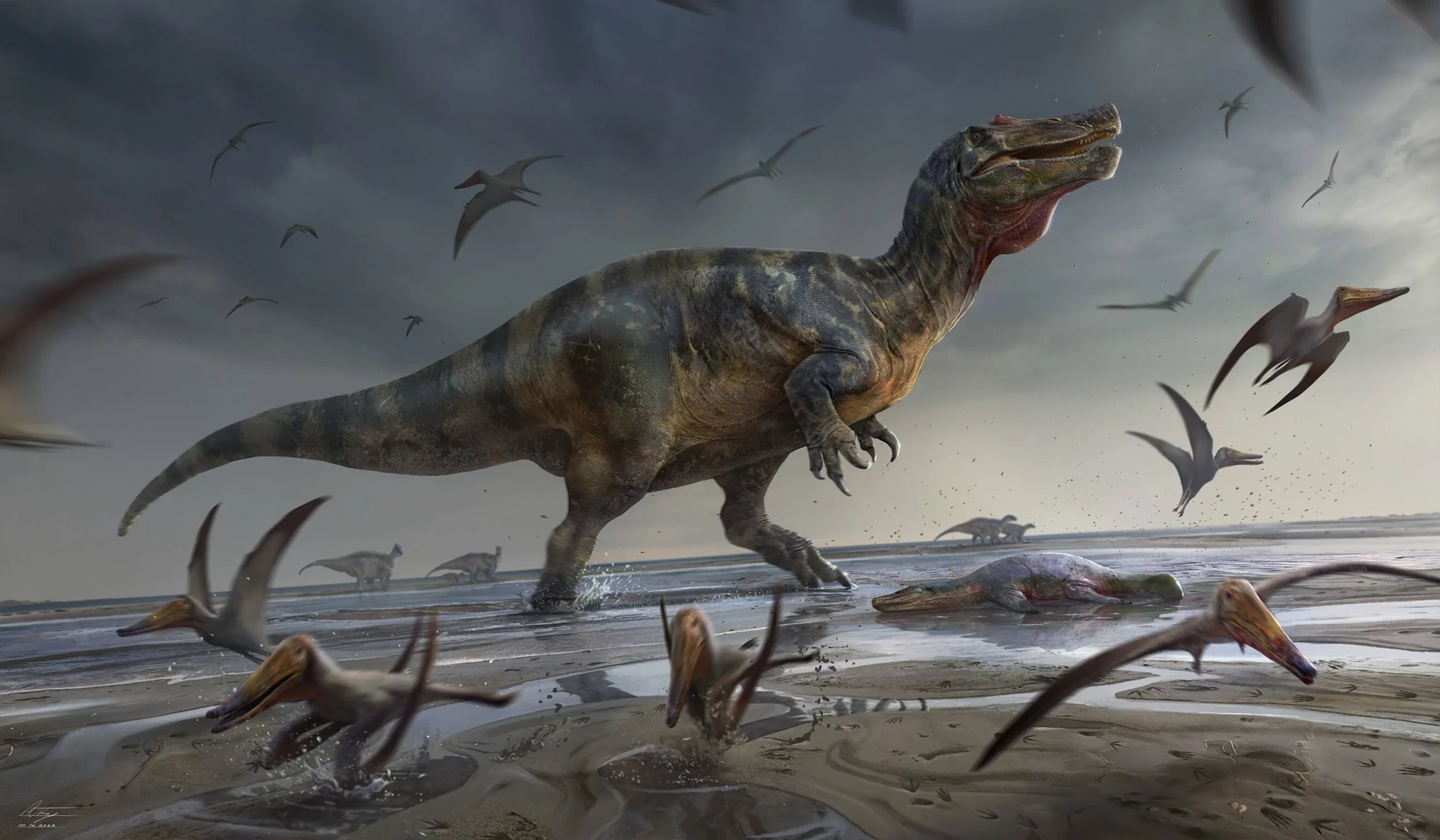 Reconstrucción artística de un gran dinosaurio carnívoro caminando por una playa junto a pterosaurios voladores y una carcasa de reptil marino.