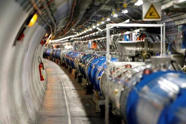Interior del túnel del LHC con tubos superconductores azules y equipamiento científico extendiéndose en perspectiva.