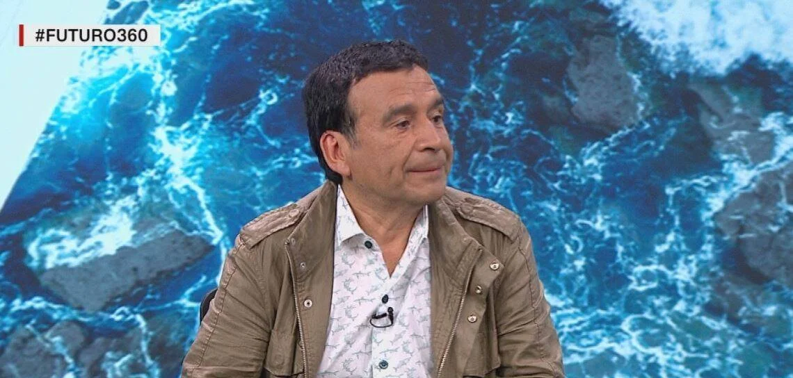 Hombre con chaqueta beige y camisa estampada participa como invitado en el programa televisivo #Futuro360.