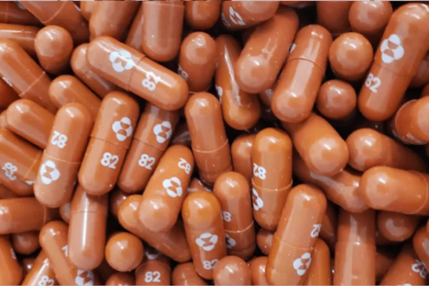 Gran cantidad de cápsulas farmacéuticas de color marrón con el número 82 y un logotipo impreso en blanco.