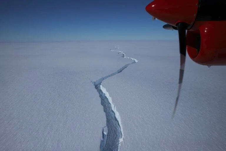 Vista aérea desde avión de una enorme grieta que atraviesa una plataforma de hielo en la Antártida.