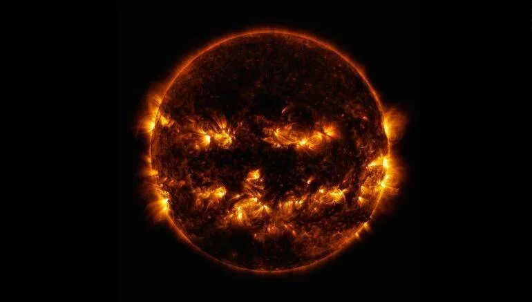El Sol fotografiado en luz ultravioleta extrema muestra regiones activas que forman una cara de jack-o-lantern de Halloween.