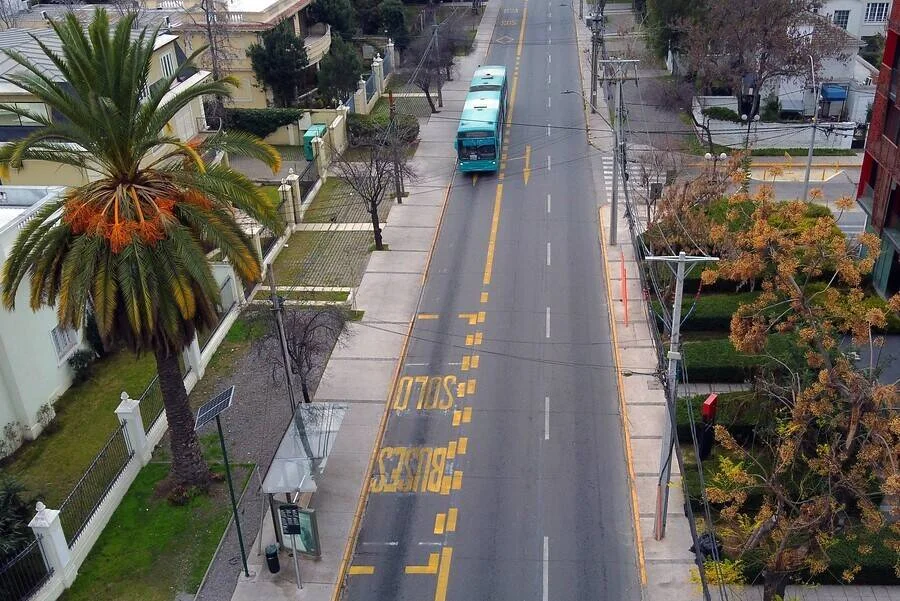 Vista aérea de una avenida urbana con un bus circulando por un carril exclusivo marcado 'Solo Buses' en pintura amarilla.