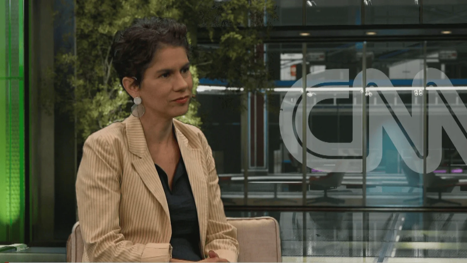 Mujer con blazer beige sentada en el estudio de CNN durante una entrevista televisiva.