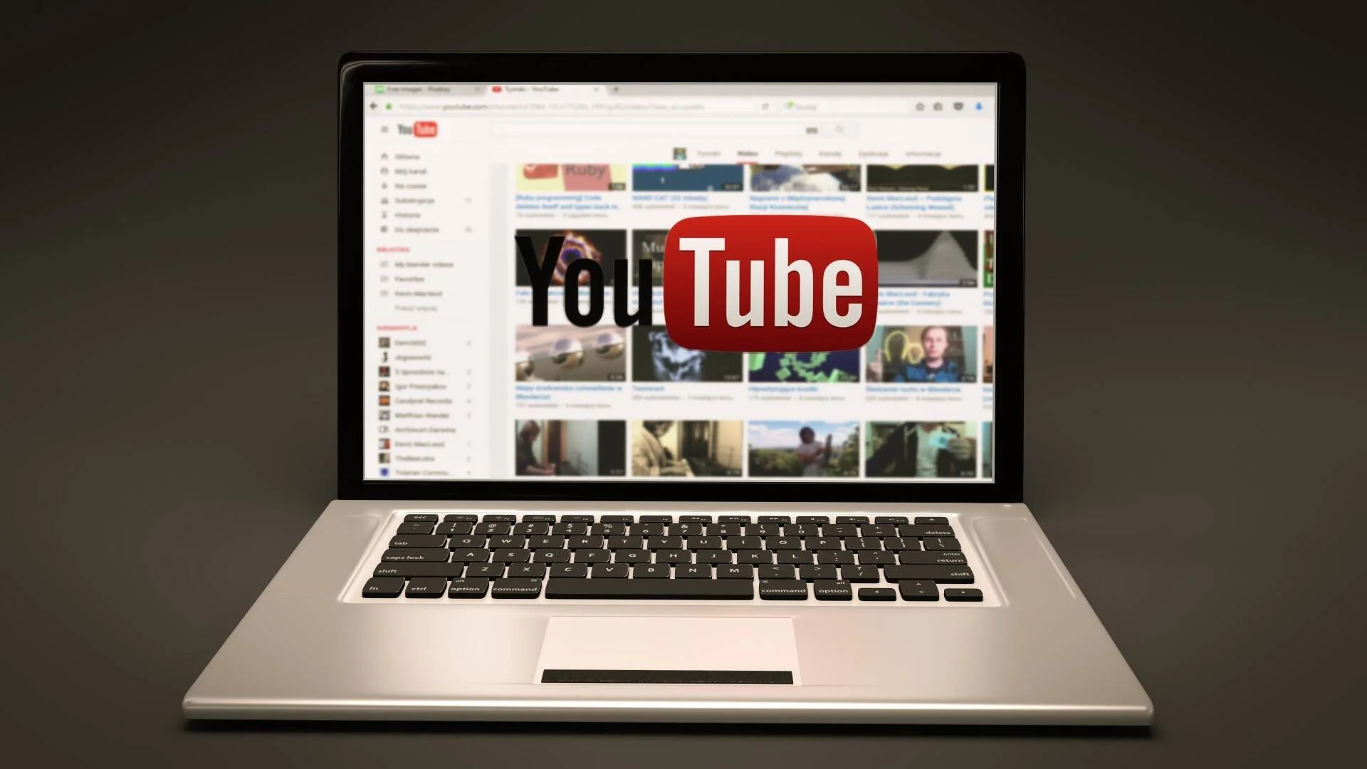 Computadora portátil mostrando la página de YouTube con su logotipo destacado en el centro de la pantalla.