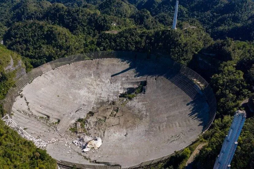 Vista aérea del enorme disco del radiotelescopio de Arecibo con escombros en su interior tras el colapso de la plataforma suspendida.