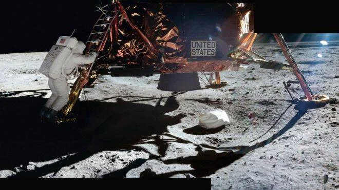 Astronauta con traje espacial desciende la escalerilla del módulo lunar de Estados Unidos sobre la superficie de la Luna.