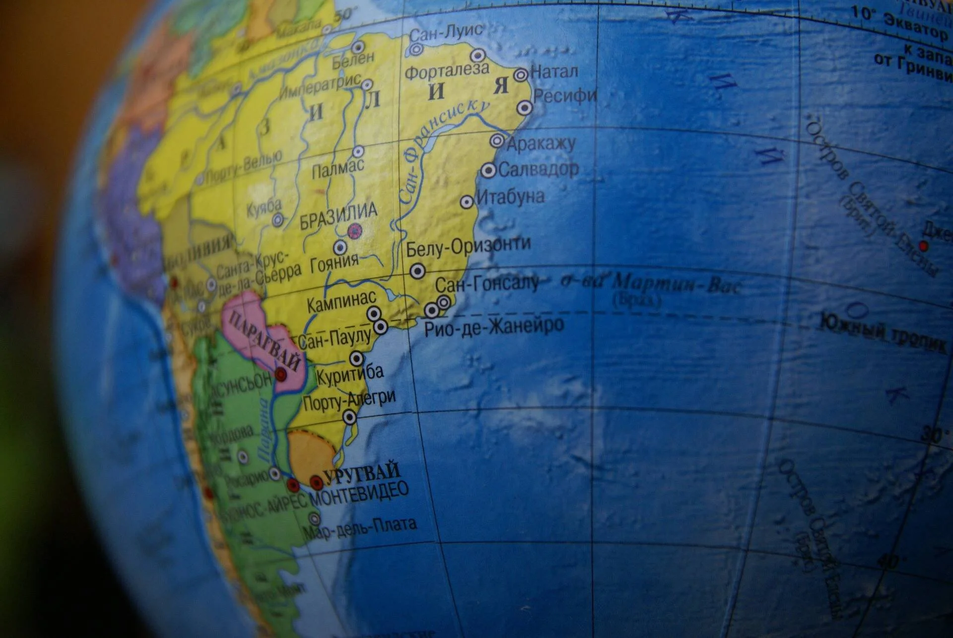 Globo terráqueo en ruso mostrando Brasil, Paraguay y Uruguay con sus principales ciudades marcadas.