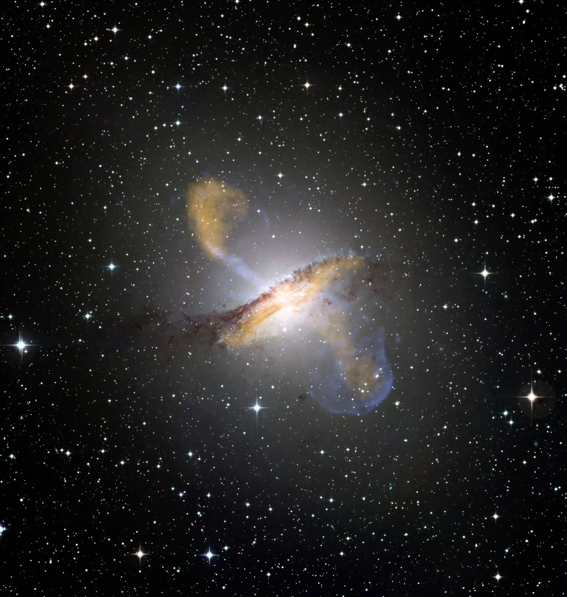 Galaxia elíptica con una banda de polvo oscura en su centro y dos jets de plasma azulado y naranja proyectados en direcciones opuestas.