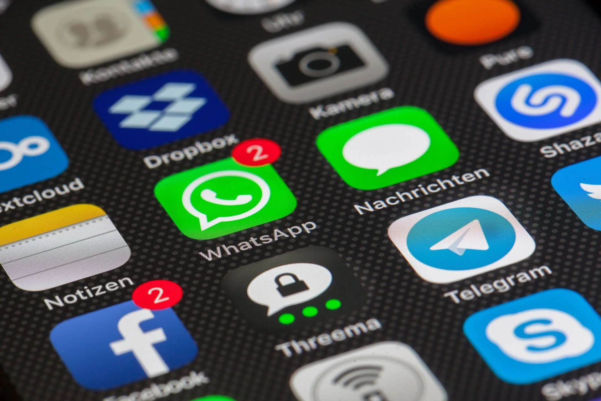 Pantalla de smartphone con iconos de aplicaciones de mensajería como WhatsApp, Telegram, Facebook y Threema, con notificaciones pendientes.