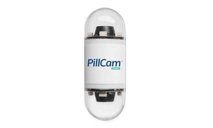 Cápsula endoscópica PillCam COLON 2 con cámaras en ambos extremos para exploración del colon.