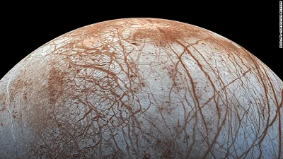 Vista de Europa, luna de Júpiter, con su superficie de hielo surcada por líneas rojizas y fracturas.