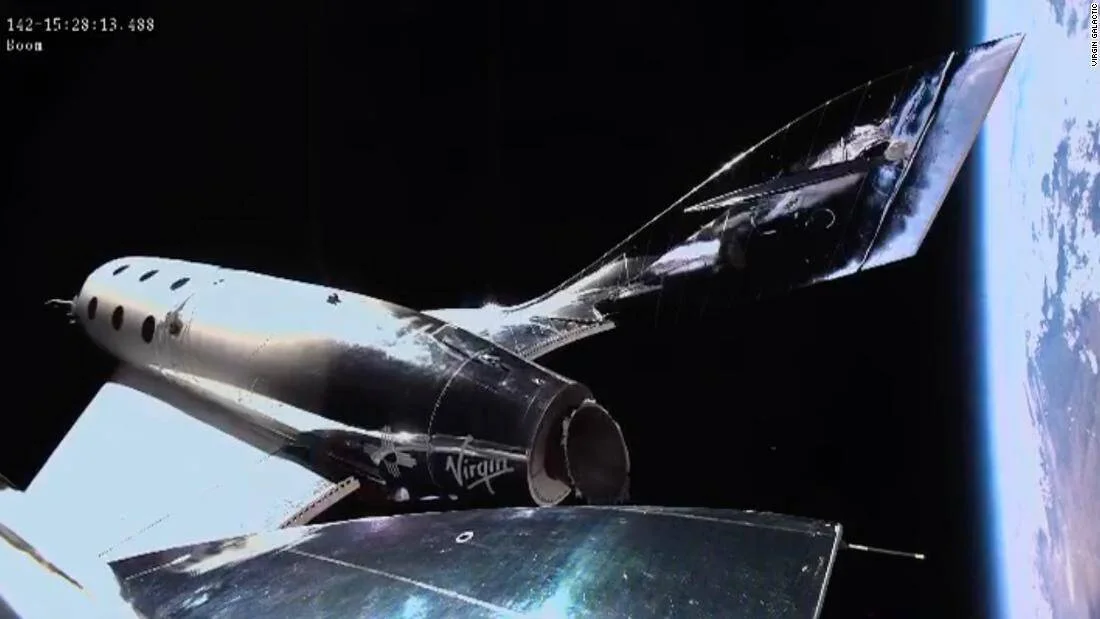 La nave espacial de Virgin Galactic fotografiada desde el exterior con la curvatura de la Tierra visible al fondo durante un vuelo suborbital.