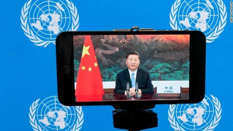 Pantalla de teléfono muestra a un dirigente chino hablando ante la ONU, con la bandera de China y fondo de la Gran Muralla.