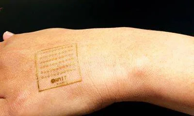Parche electrónico ultradelgado y flexible pegado sobre el dorso de una mano humana.