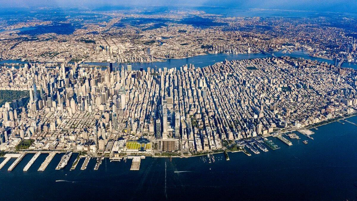 Panorámica aérea de Manhattan con sus rascacielos, rodeada por el río Hudson y el East River, con los demás boroughs al fondo.