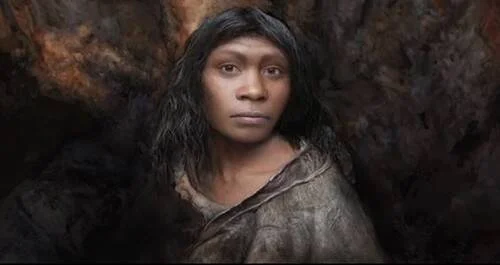 Reconstrucción facial digitalizada de una mujer prehistórica con piel oscura, cabello negro y vestimenta de piel animal, en cueva.