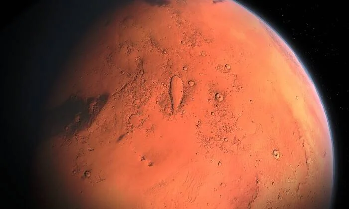 Vista cercana de Marte desde el espacio, mostrando su superficie rojiza con cráteres y el fondo estrellado negro.