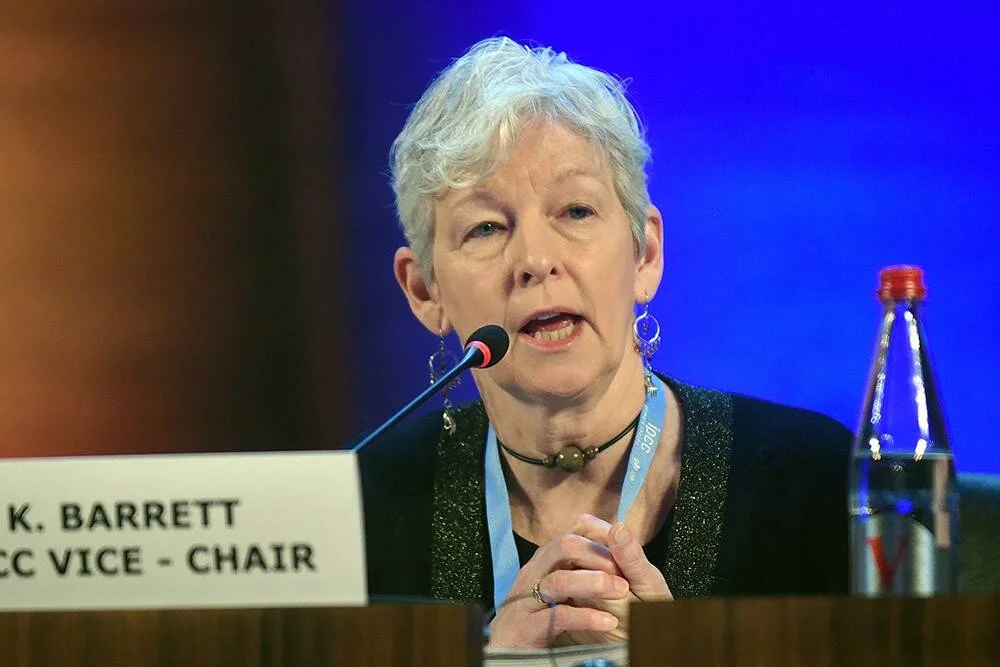 K. Barrett, vicepresidenta del IPCC, habla ante un micrófono en una mesa de conferencia.
