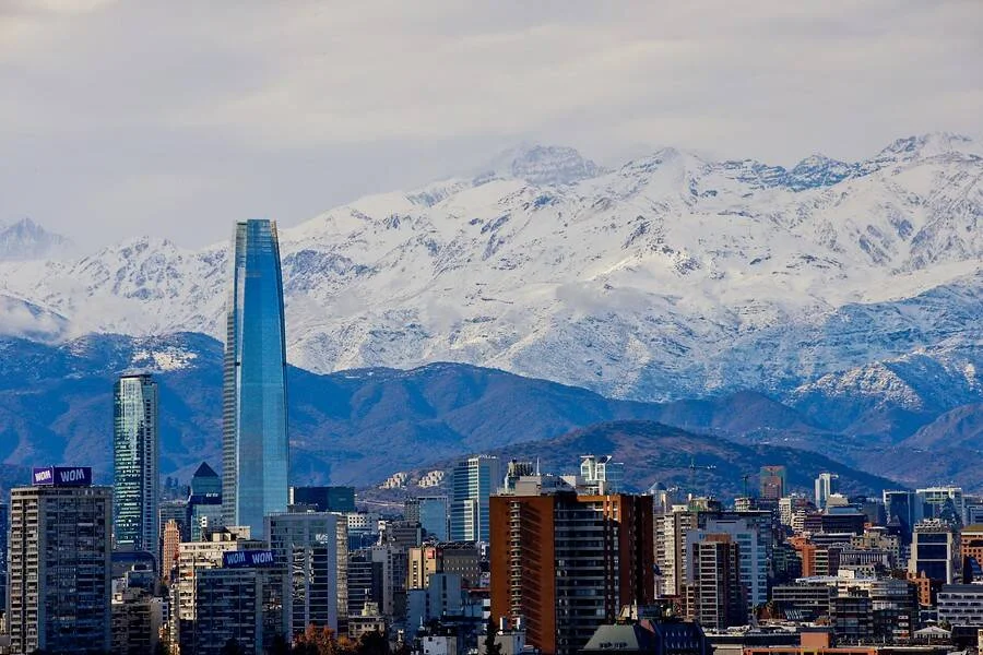 Vista panorámica del skyline de Santiago de Chile con la Cordillera de los Andes cubierta de nieve al fondo.