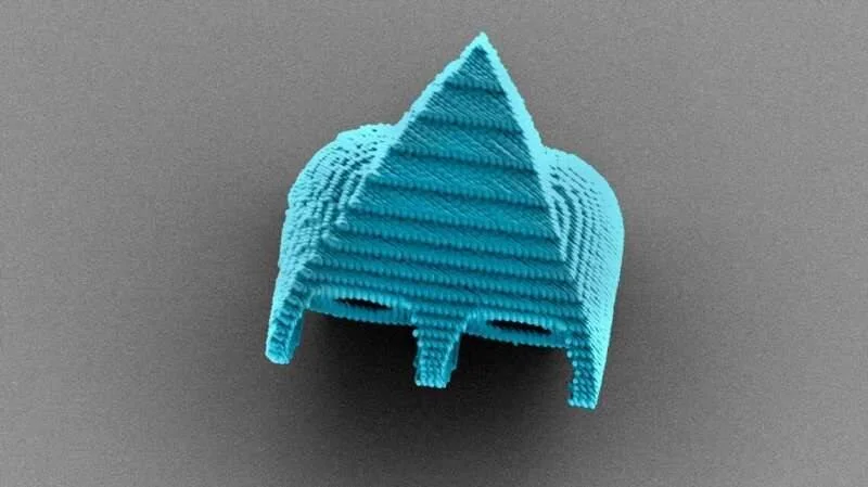 Micrografía coloreada de una estructura 3D microscópica en azul con forma piramidal y capas apiladas visibles.