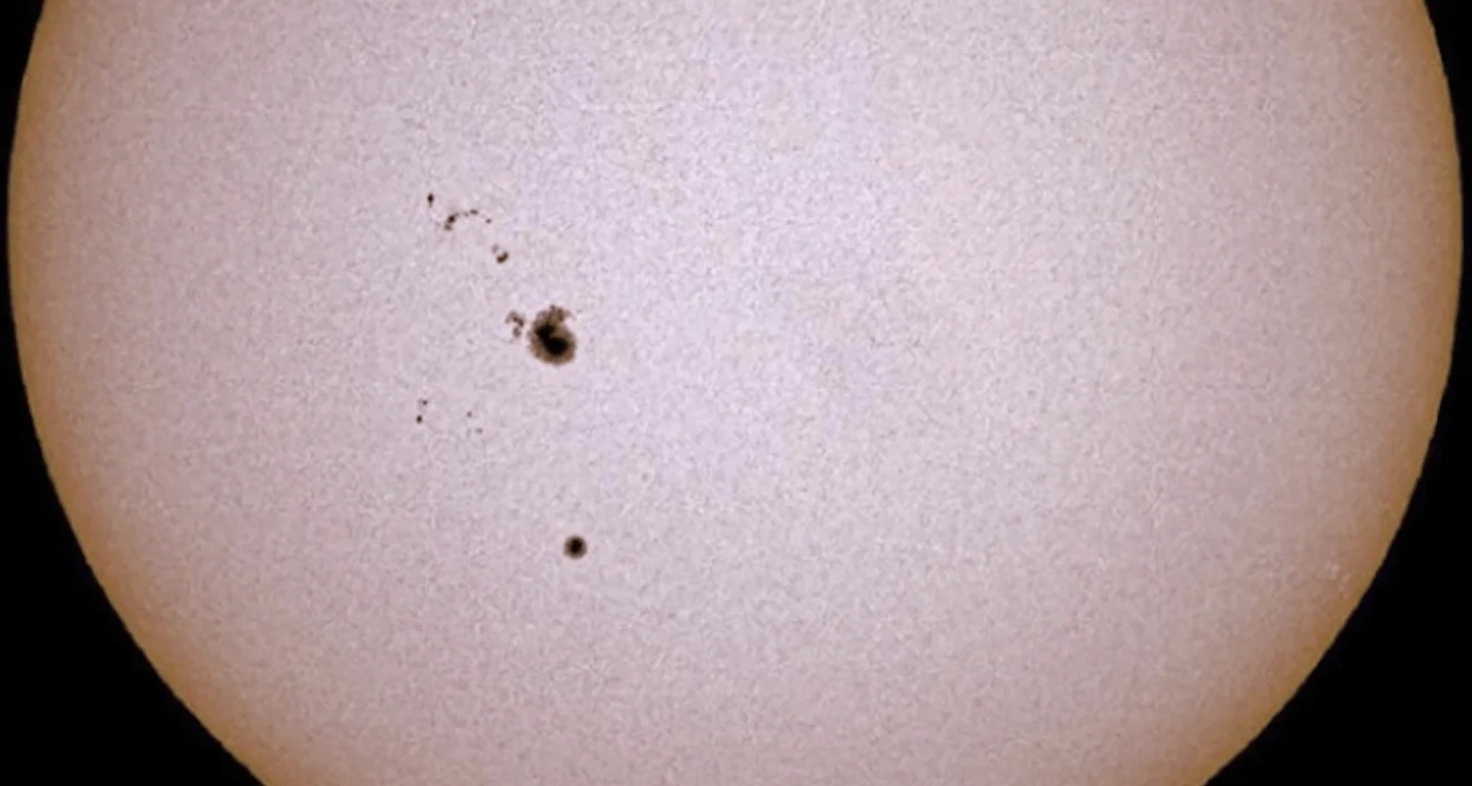 Vista telescópica del Sol mostrando un grupo de manchas solares oscuras sobre la fotosfera.