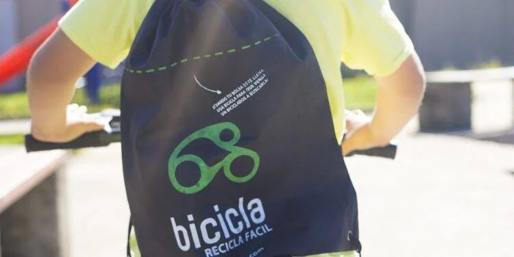 Persona con mochila negra del programa Bicicla Recicla Fácil, con logo de bicicleta verde.