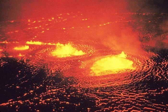 Vista aérea de un lago de lava incandescente con remolinos de magma fundido en rojo y amarillo intenso.