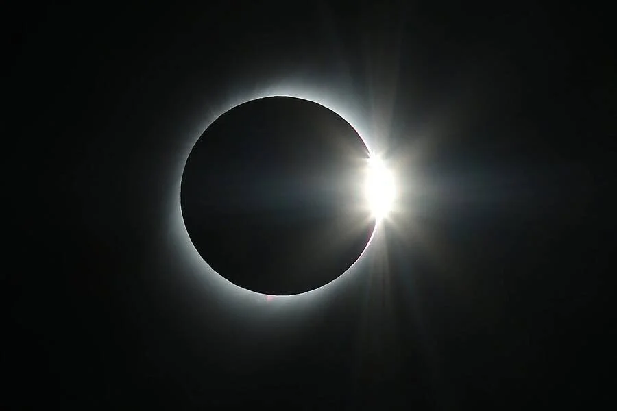 Eclipse solar total en fase de anillo de diamante: la Luna cubre el Sol dejando un destello brillante en el borde derecho y la corona solar visible.