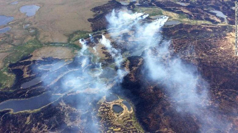 Vista aérea de múltiples incendios forestales activos con columnas de humo sobre la tundra de Alaska.
