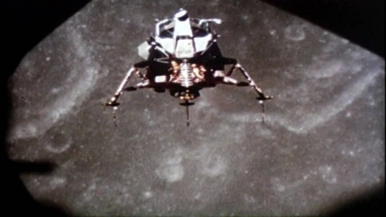 Módulo lunar con patas desplegadas desciende sobre la superficie gris y craterizada de la Luna.