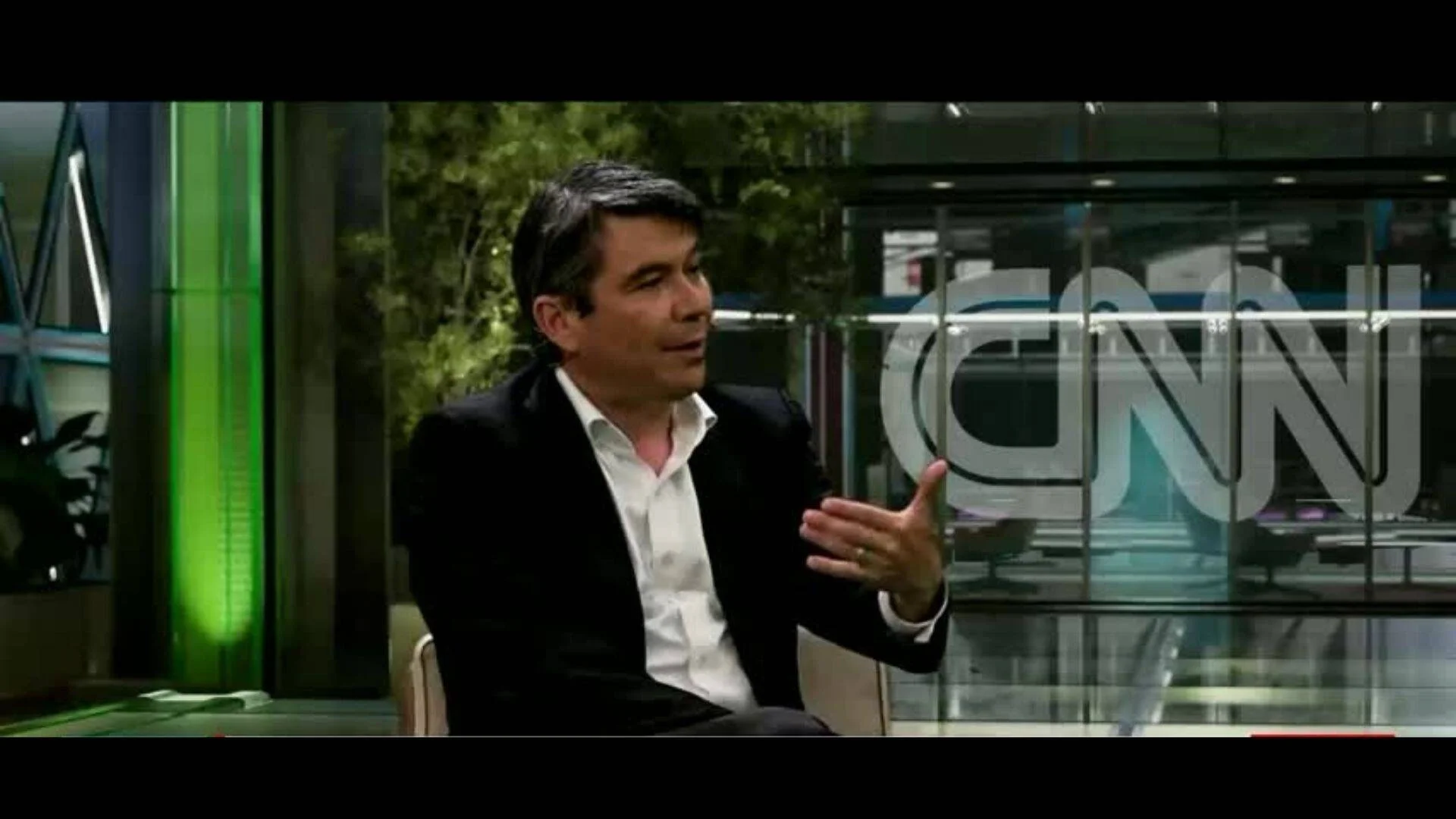 Un hombre con saco negro habla gesticulando en el estudio de CNN durante una entrevista televisiva.