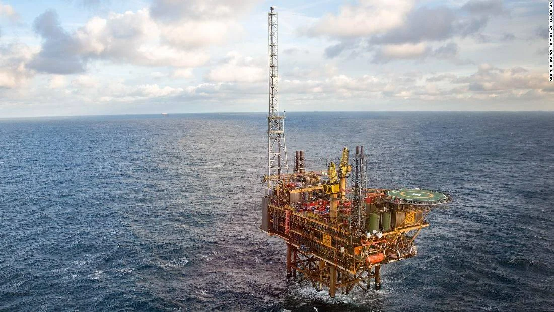 Plataforma de extracción de petróleo y gas ubicada en alta mar, rodeada de aguas abiertas bajo un cielo parcialmente nublado.