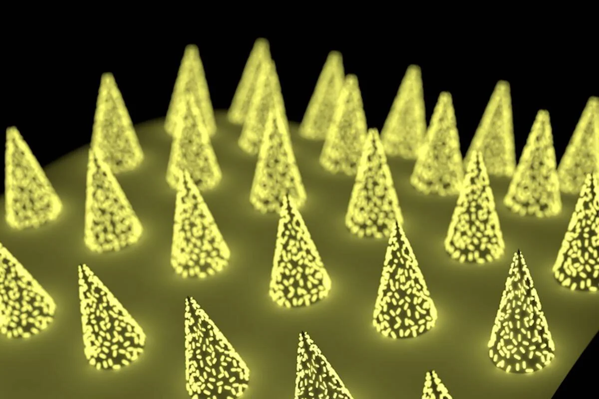 Representación artística de microconos cónicos con textura de nanopartículas brillantes en color amarillo sobre fondo negro.