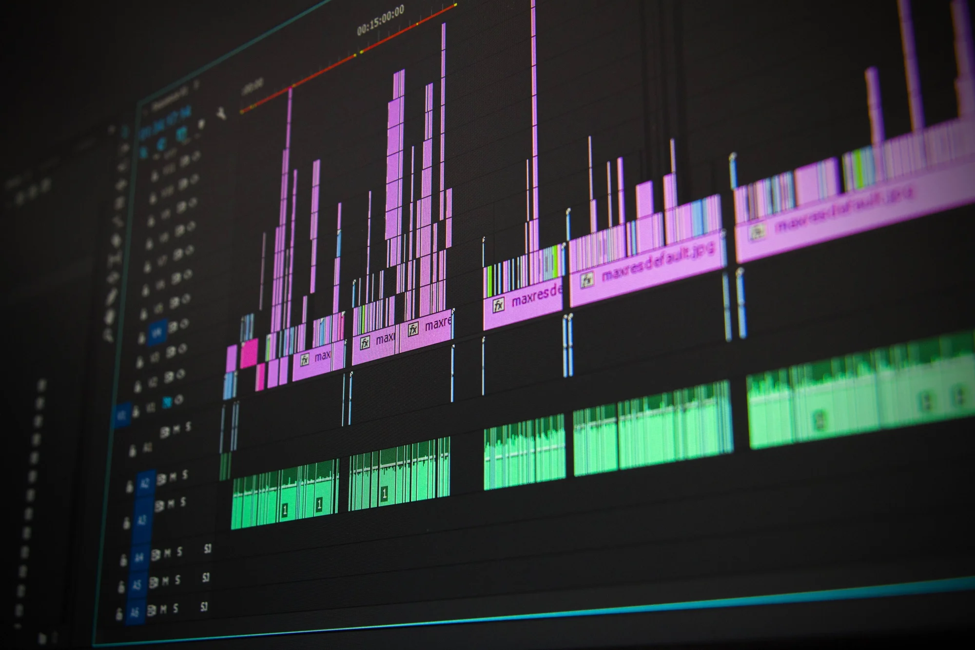 Pantalla de software de edición de video mostrando una línea de tiempo con pistas de video en rosa y audio en verde.