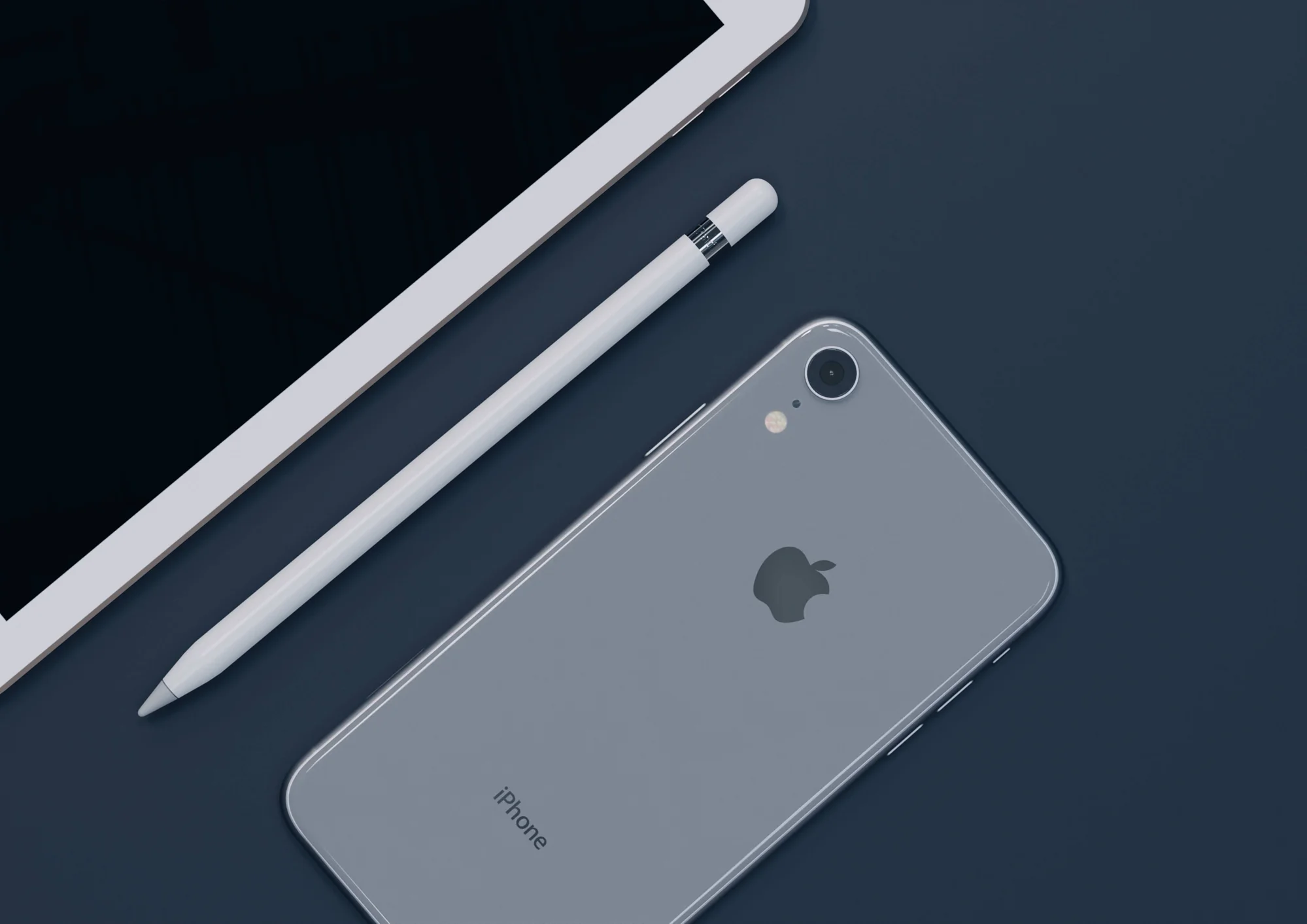 Vista trasera de un iPhone junto a un Apple Pencil y una tablet iPad sobre fondo azul oscuro.