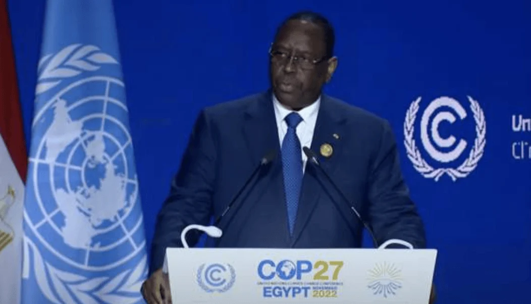 Líder africano con traje azul habla en el podio de la COP27, celebrada en Egipto en noviembre de 2022, con la bandera de la ONU al fondo.