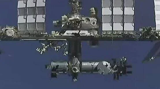 Vista exterior de la Estación Espacial Internacional con sus paneles solares desplegados sobre fondo azul del espacio.