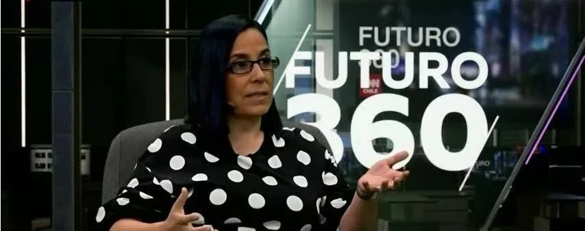 Mujer con blusa de lunares y cabello azul habla durante una entrevista en el programa televisivo Futuro 360.