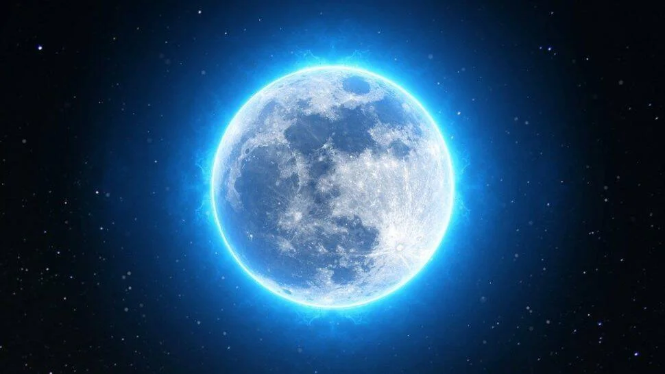 Luna llena rodeada de un resplandor azul intenso sobre un fondo de cielo nocturno estrellado.
