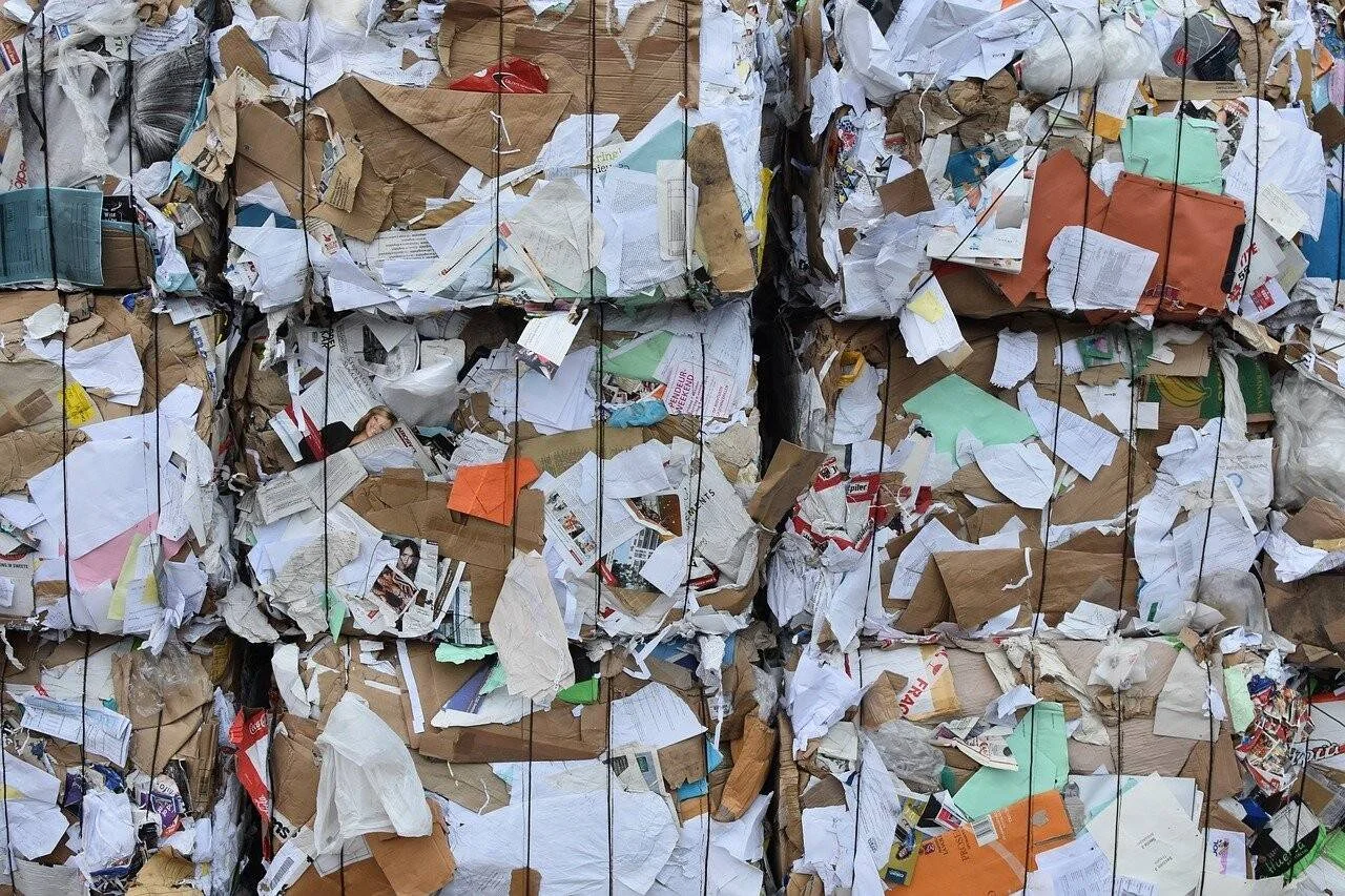 Grandes bloques de papel, cartón y documentos compactados y atados con alambre listos para ser reciclados.