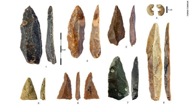 Colección de herramientas líticas prehistóricas talladas en piedra, numeradas del 1 al 8, sobre fondo blanco con escala de referencia.