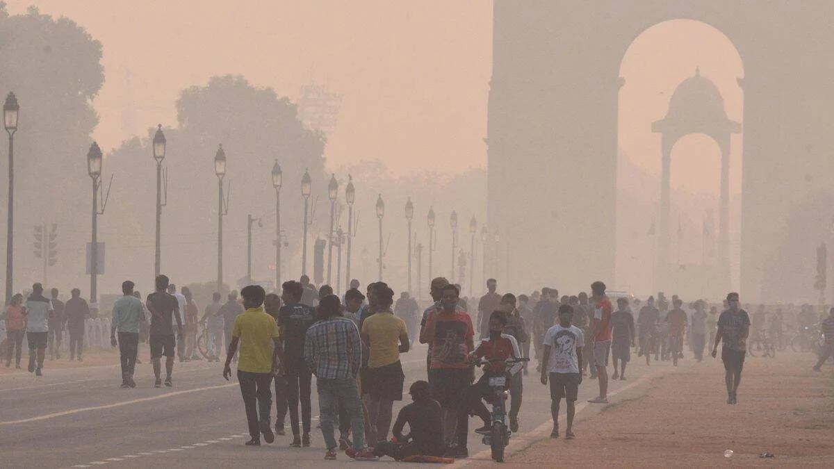 Personas caminan frente a India Gate en Nueva Delhi envuelta en una densa capa de smog que reduce drásticamente la visibilidad.