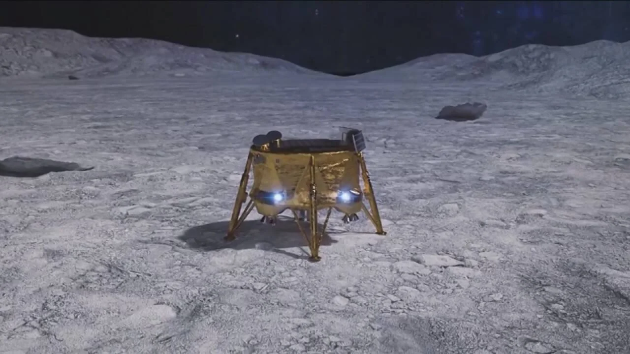 Recreación artística de un módulo de aterrizaje espacial de color dorado posado sobre la superficie lunar rocosa bajo un cielo estrellado.
