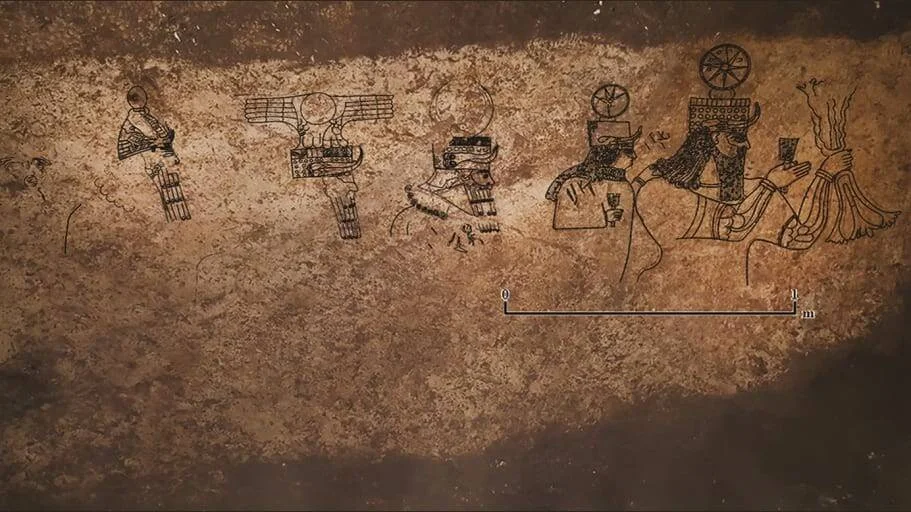 Grabados rupestres sobre roca ocre que muestran varias figuras antropomorfas con tocados elaborados y escala métrica de referencia.