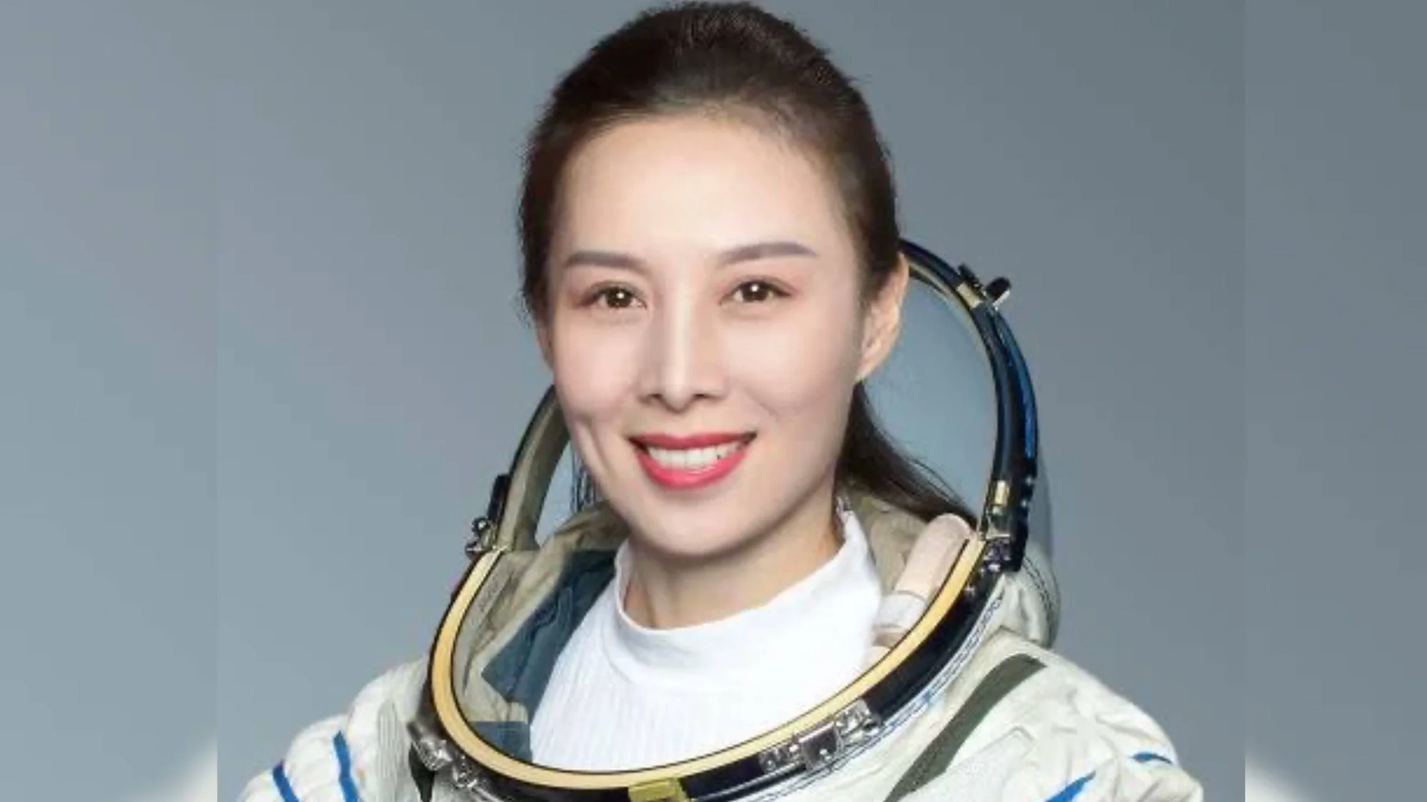 Mujer joven con traje espacial blanco y casco abierto sonríe en foto de perfil oficial.