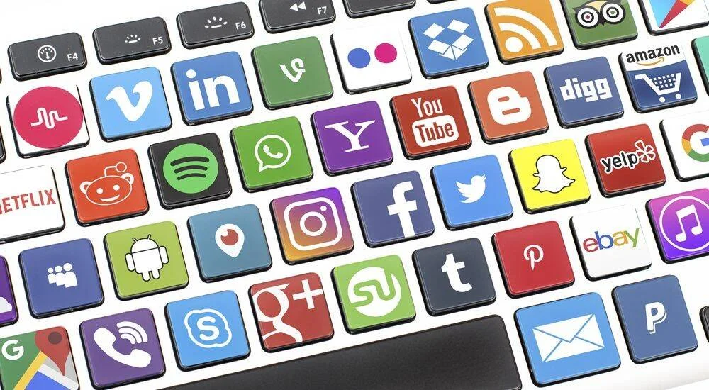 Teclado de computadora cuyas teclas muestran logotipos de redes sociales y plataformas digitales como Facebook, Twitter, Instagram y YouTube.