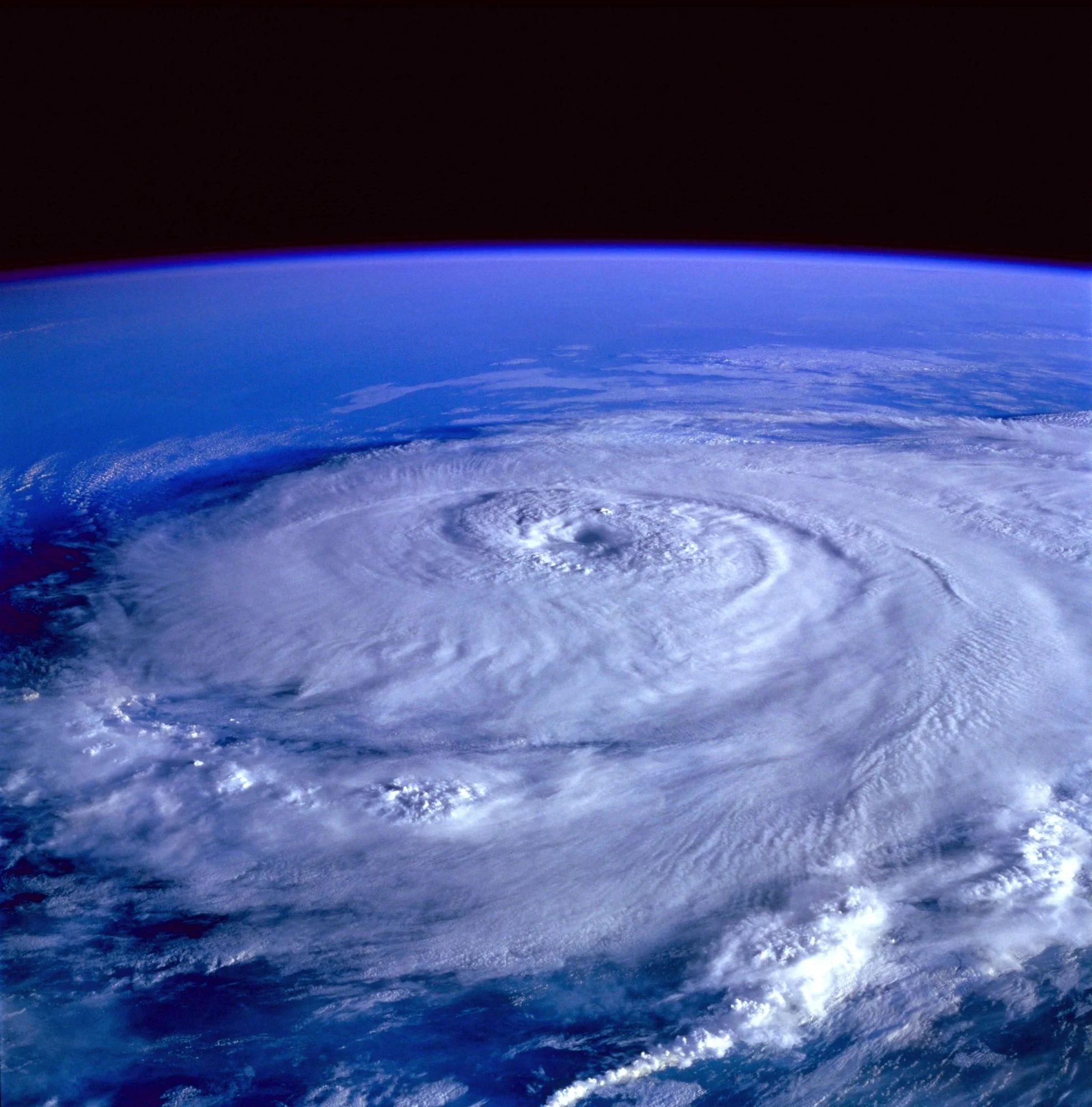 Vista satelital de un huracán con su ojo bien definido y bandas de nubes en espiral sobre el océano.