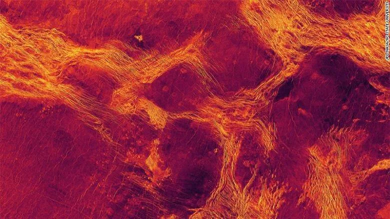 Imagen de radar de la superficie de Venus en tonos rojos y anaranjados, mostrando estructuras geológicas y fracturas del terreno.