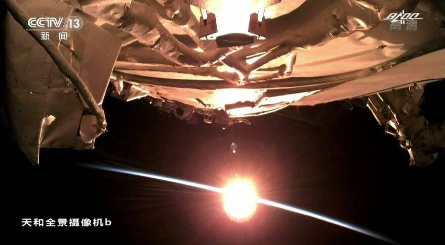 Vista desde la cámara panorámica Tianhe de la estación espacial china con el sol asomando sobre el horizonte terrestre, transmitida por CCTV 13.